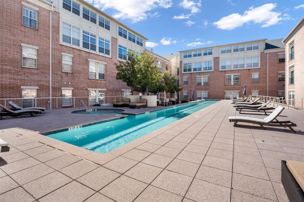 Outdoor pool area featuring a multi-level concrete deck, integrated spa, perimeter metal railings, and mature trees