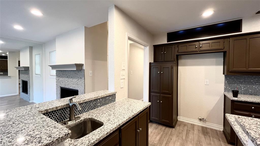 Kitchen featuring dark cabinetry, speckled stone-finish countertops, and an undermount stainless steel sink Kitchen featuring dark cabinetry, speckled stone-finish countertops, and an undermount stainless steel sink
