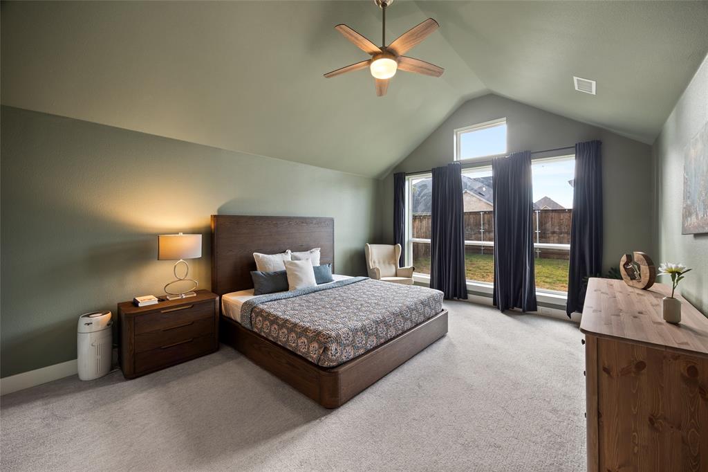 Vaulted ceilings, expansive windows, and a ceiling fan fixture