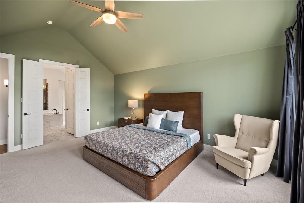 Vaulted ceiling with an integrated light-equipped ceiling fan, double-door entryway, and neutral carpeting