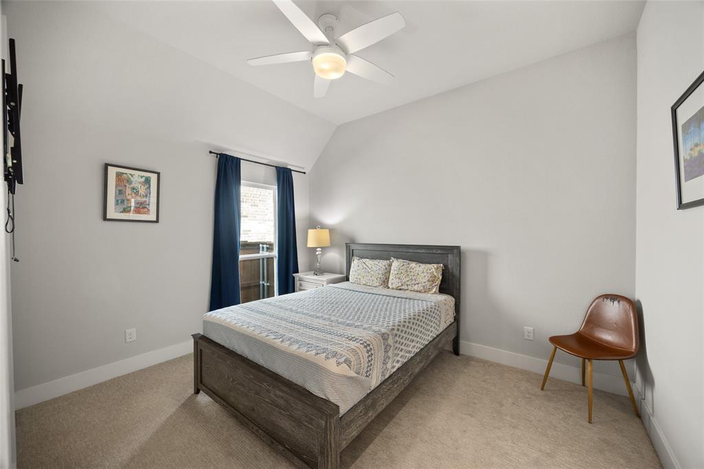 Neutral-toned room featuring high vaulted ceilings, carpeted flooring, and a central white ceiling fan with integrated lighting