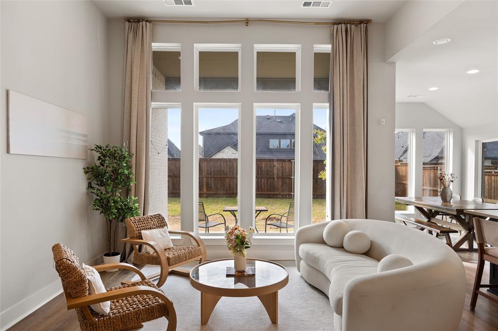 Floor-to-ceiling windows, high ceilings, recessed lighting, and wood-finish flooring