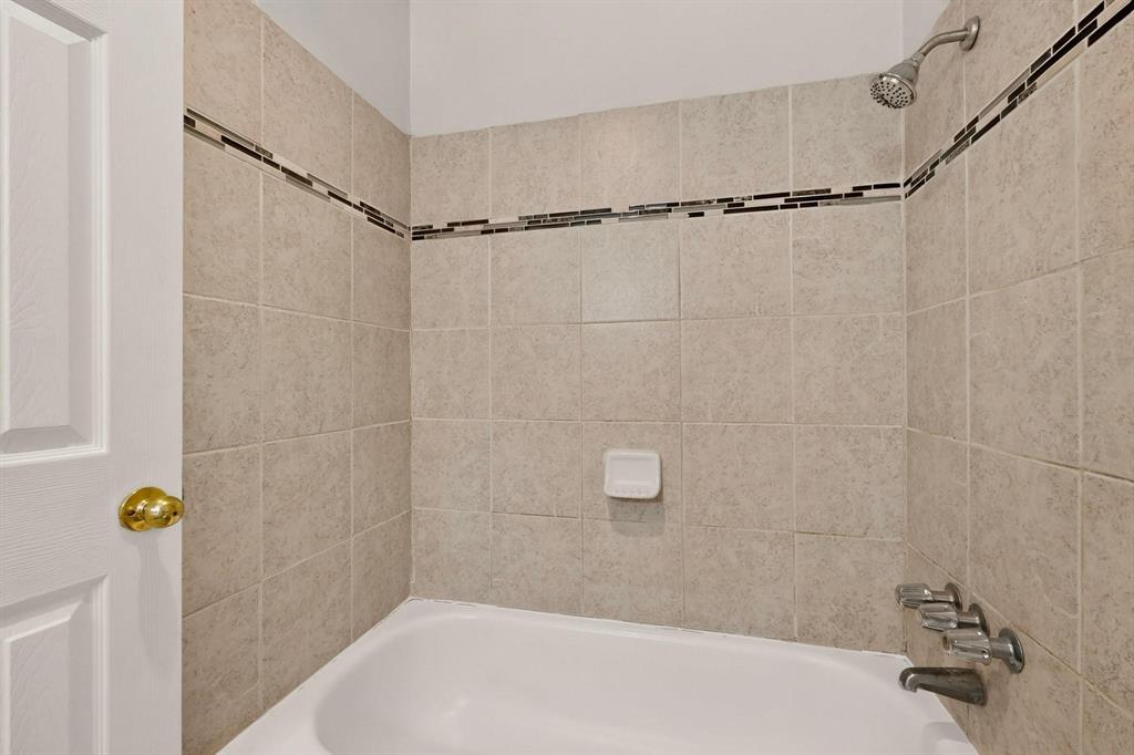A bright bathroom with an alcove tub against light-colored walls, creating a serene atmosphere.