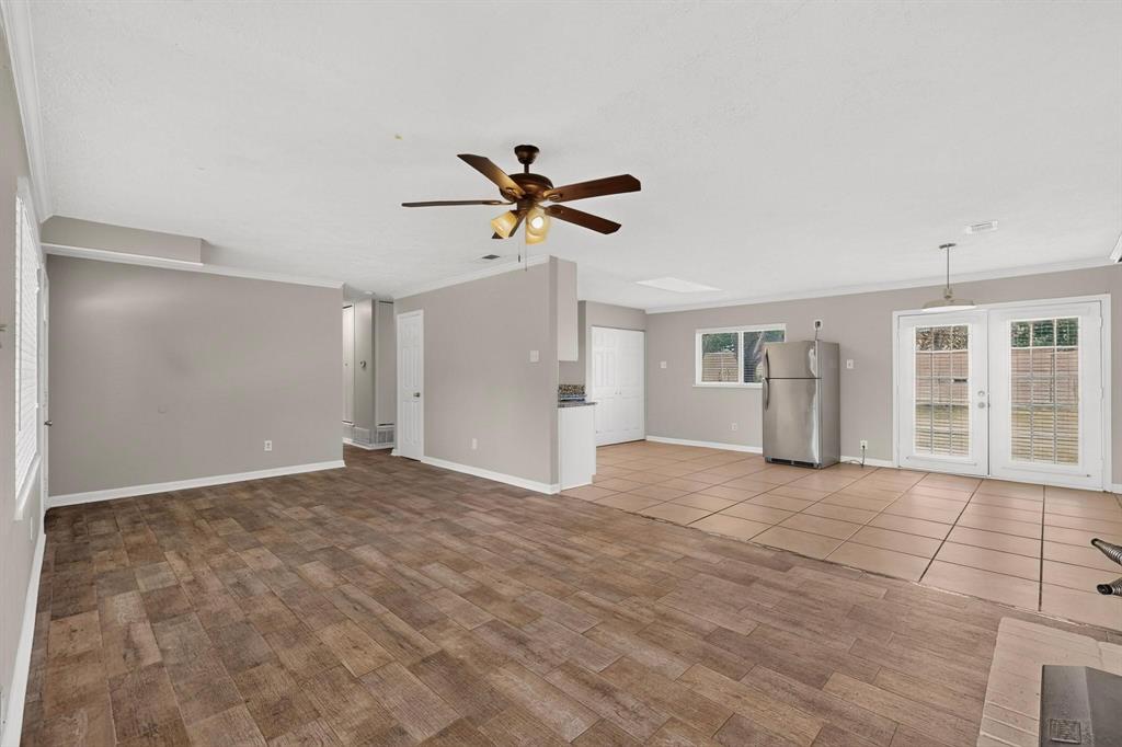 A bright living room featuring hardwood floors and a ceiling fan, ready for new furnishings and decor. A bright living room featuring hardwood floors and a ceiling fan, ready for new furnishings and decor.