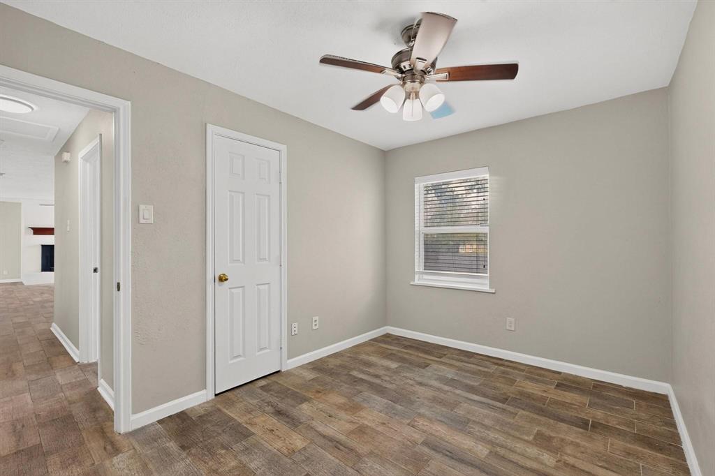 A well-lit third bedroom featuring a ceiling fan, closet and a window letting in natural light.