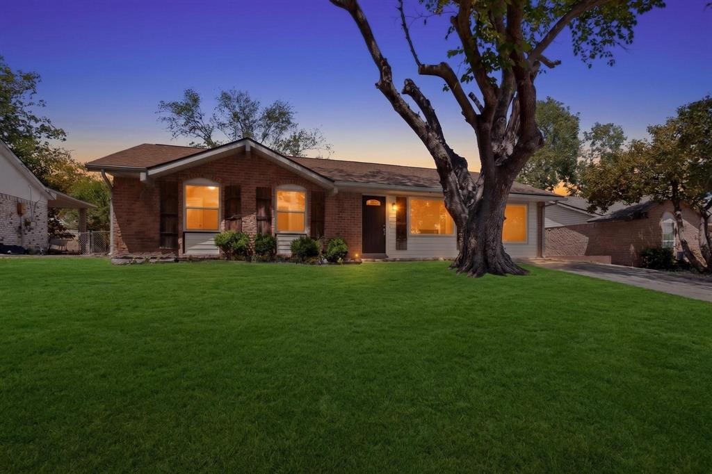 A charming house set in a large yard with lush greenery and trees around, perfect for outdoor activities and relaxation.