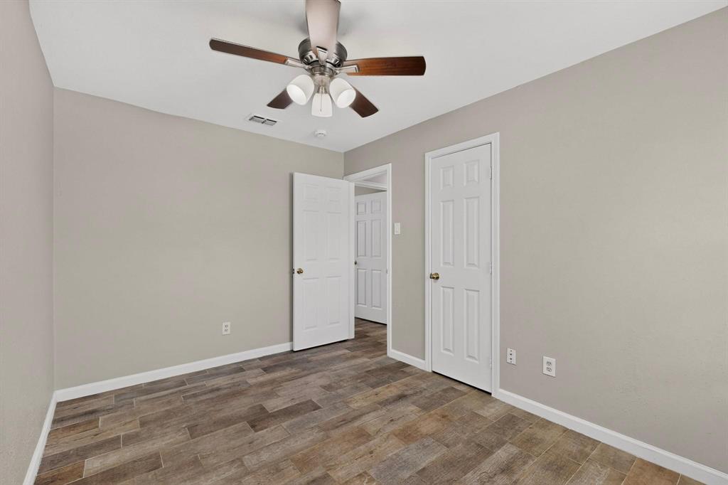 A cozy third bedroom with a ceiling fan and closet.