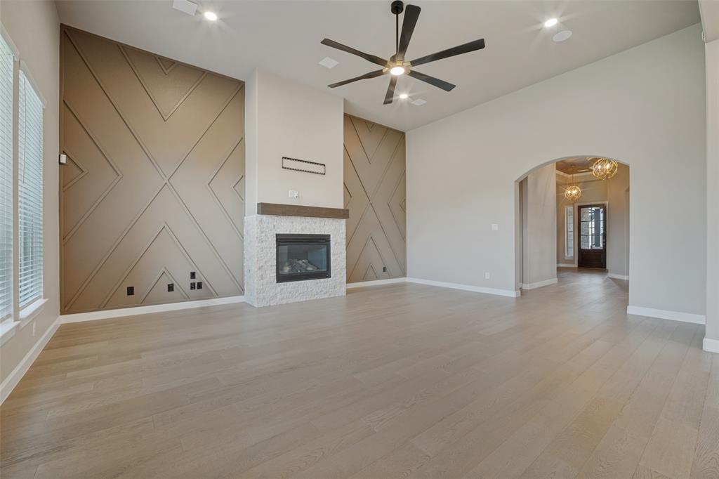 The living room features the same beautiful wood-look flooring, accent walls bookending a cozy fireplace