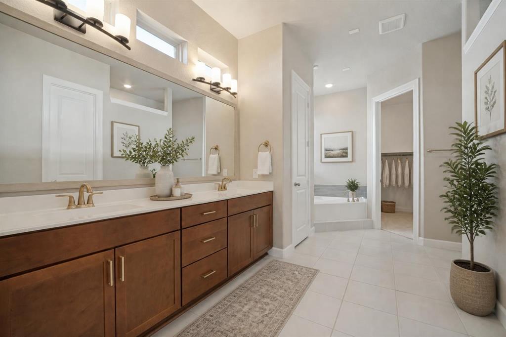 En suite primary bathroom with dual sinks, a separate soaker tub and walk in shower; Virtually staged