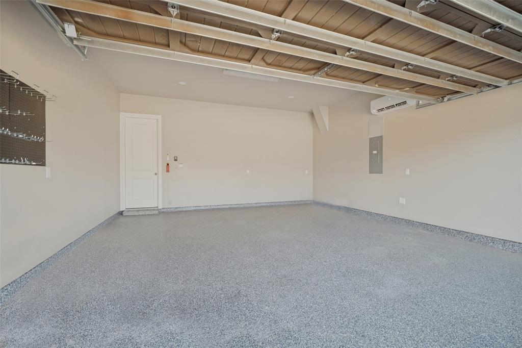 Garage with epoxy flooring and a mini-split AC system makes it much more than a typical garage for someone wanting a climate-controlled home gym, workshop, hobby space, or comfortable workspace
