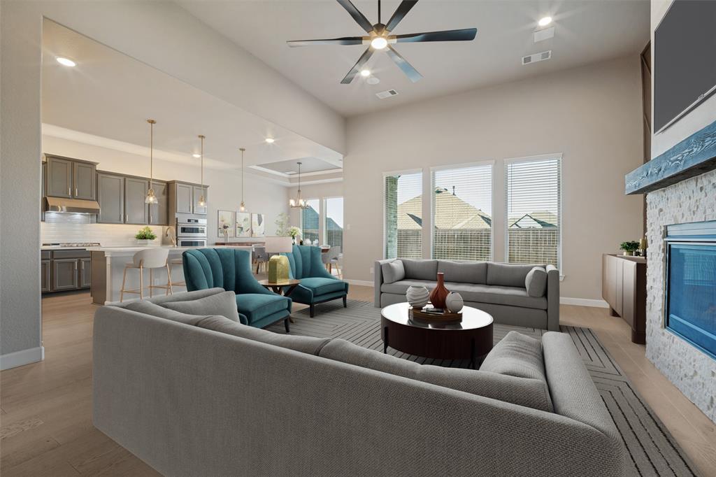 The living room features the same beautiful wood-look flooring, accent walls bookending a cozy fireplace, and flooded in natural light; Virtually staged