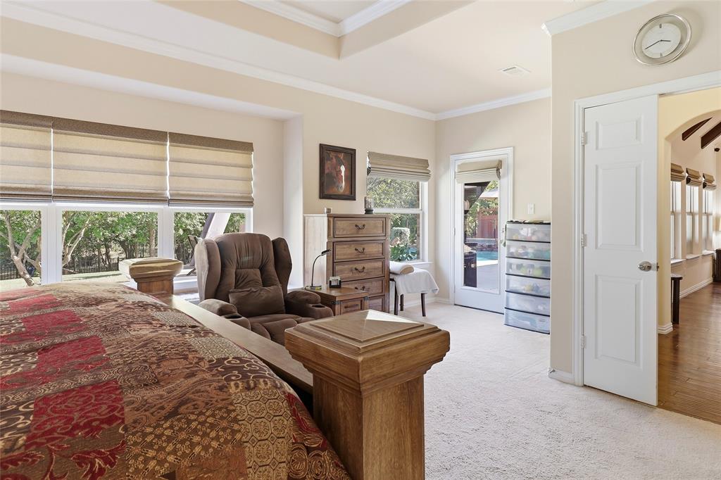 Primary bedroom features a wall of windows to enjoy the majestic peacefulness of the backyard.
