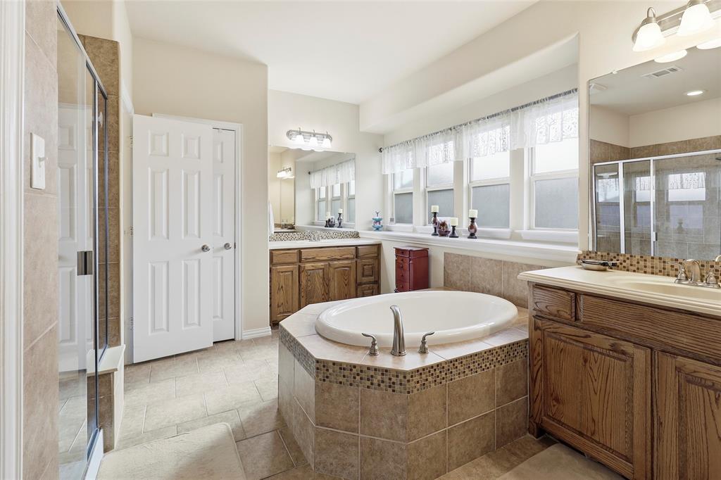 Primary Bath with large soaking tub, separate vanities, & walk in shower