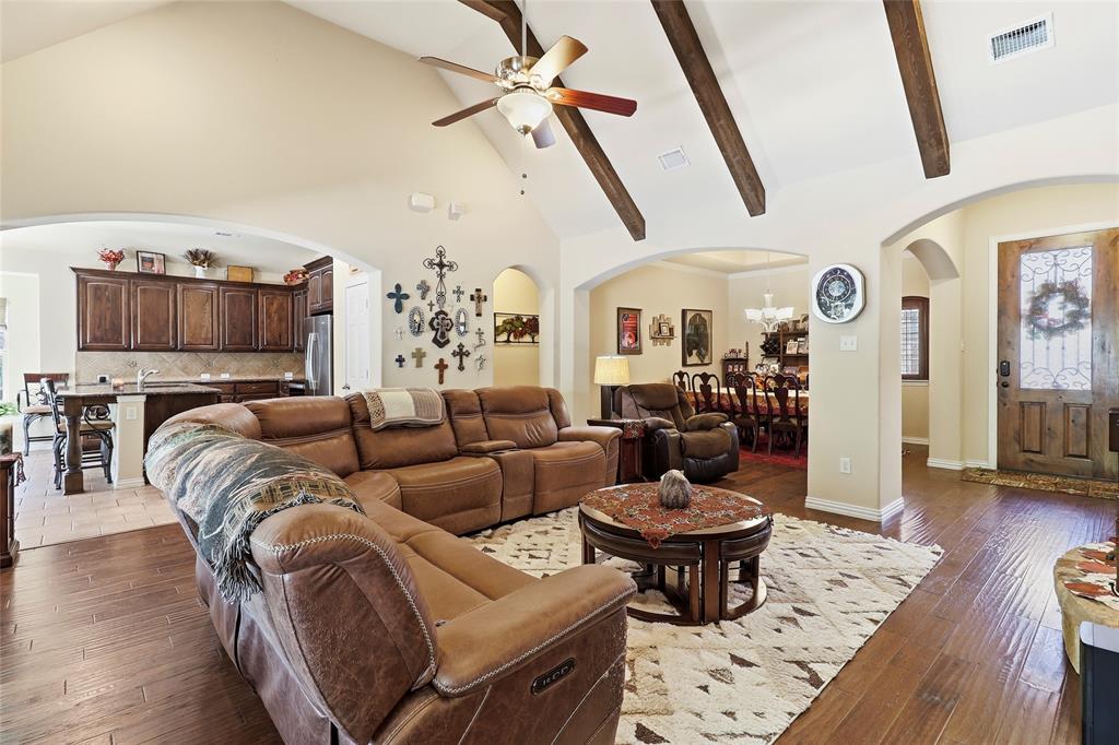 Living room features hard wood floors, beamed elevated ceilings, and fireplace