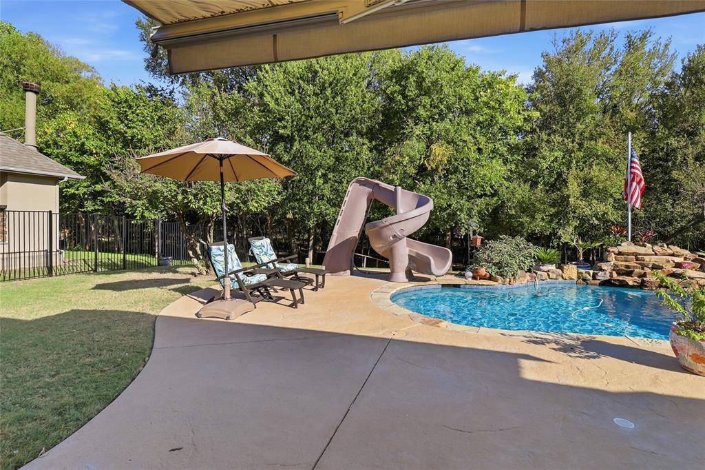 Pool slide, waterfall, grass play area and mature trees