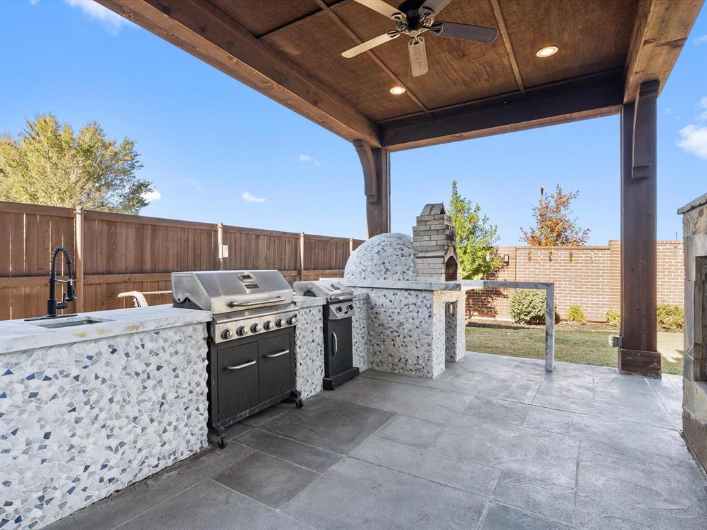 This covered patio/terrace is the ultimate outdoor entertaining space, thanks to its show-stopping outdoor kitchen. The crowning glory is a professional brick pizza oven, perfect for whipping up delicious pizzas that will impress family and friends alike.