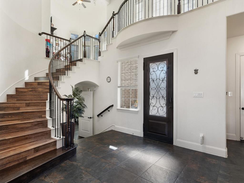 The entrance boasts an impressive high ceiling, a dazzling chandelier, and exquisite stone tile flooring that sets the tone for elegance.