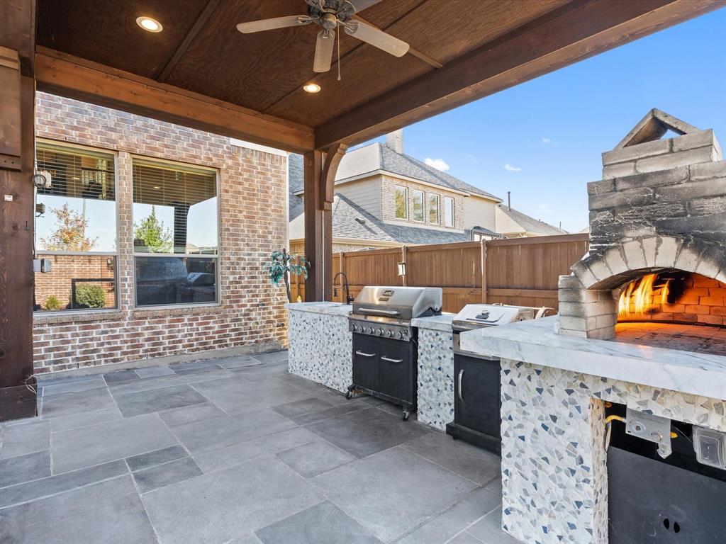 The covered patio/terrace is a true showstopper, featuring a one-of-a-kind outdoor kitchen with a professional brick pizza oven that's sure to elevate your outdoor dining experience.