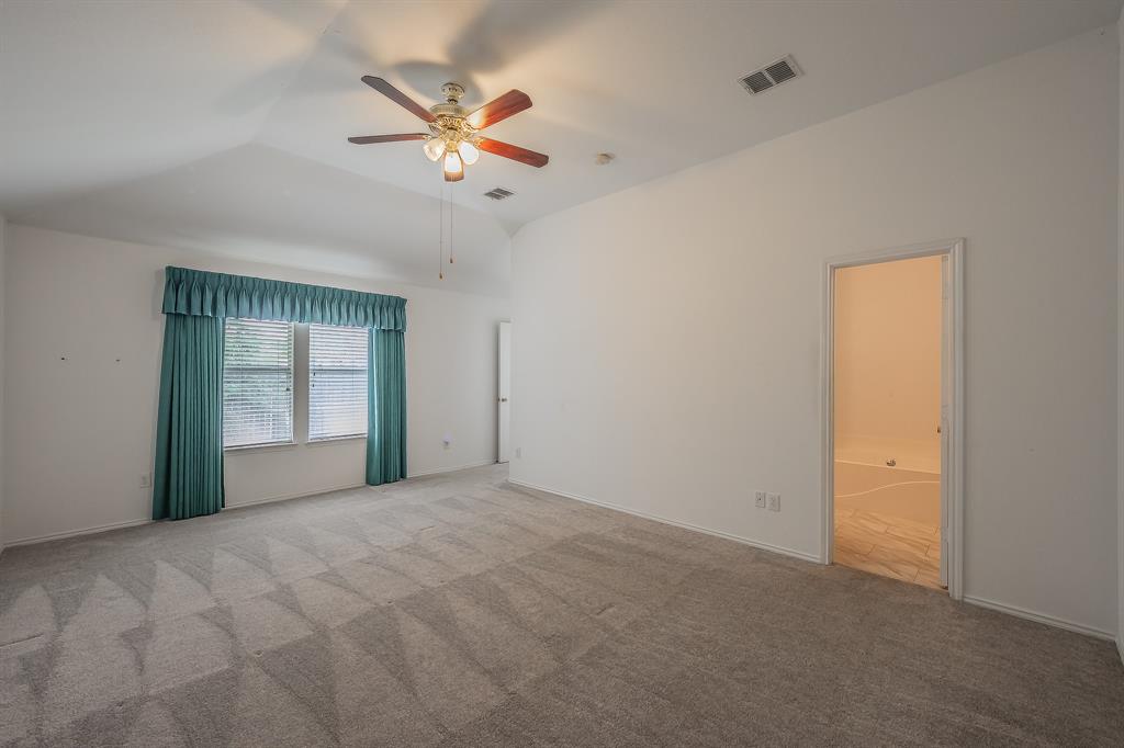 Vaulted ceilings, carpeted flooring, and a multi-blade ceiling fan with integrated light fixture