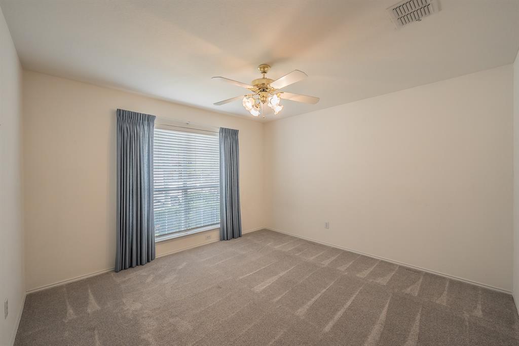 Neutral wall palette featuring carpeting, a multi-blade ceiling fan with integrated lighting, and a window with horizontal blinds