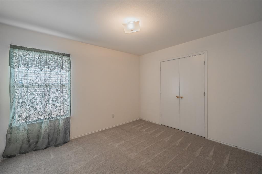Neutral interior room featuring wall-to-wall carpeting, dual-door reach-in closet, and flush-mount ceiling lighting