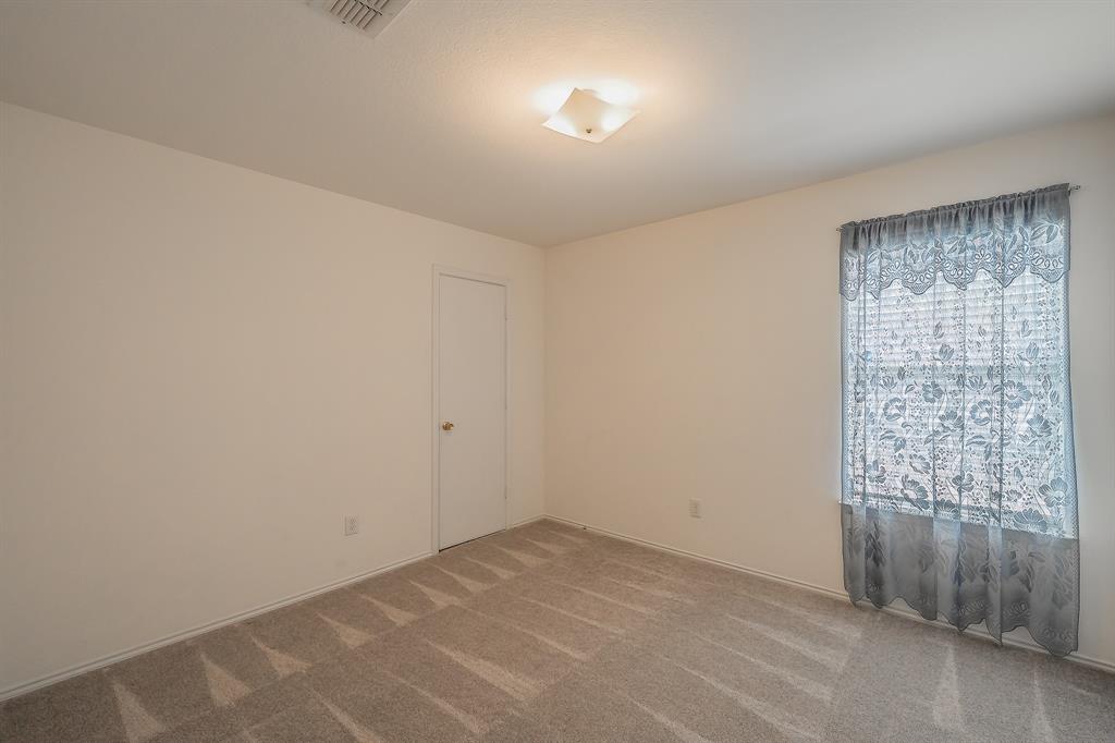 Interior space featuring neutral wall tones, wall-to-wall carpeting, a single-panel interior door, and a flush-mount light fixture