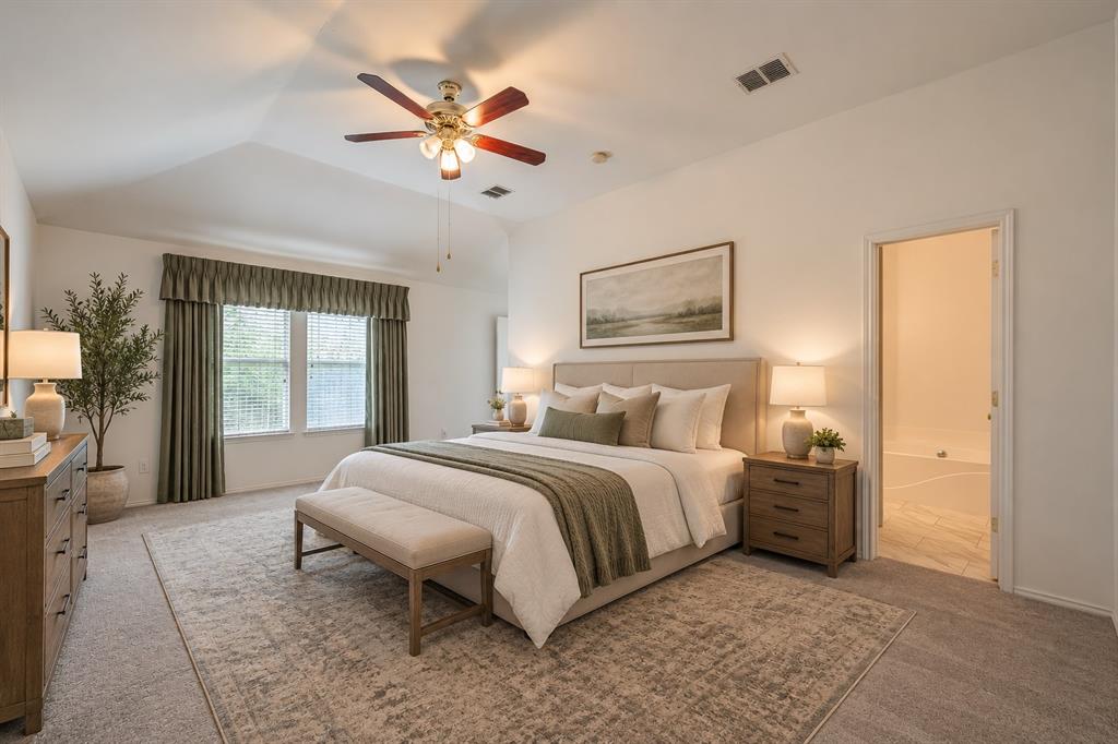 Vaulted ceiling, multi-blade ceiling fan with integrated lighting, dual windows with decorative cornice, and carpeted flooring