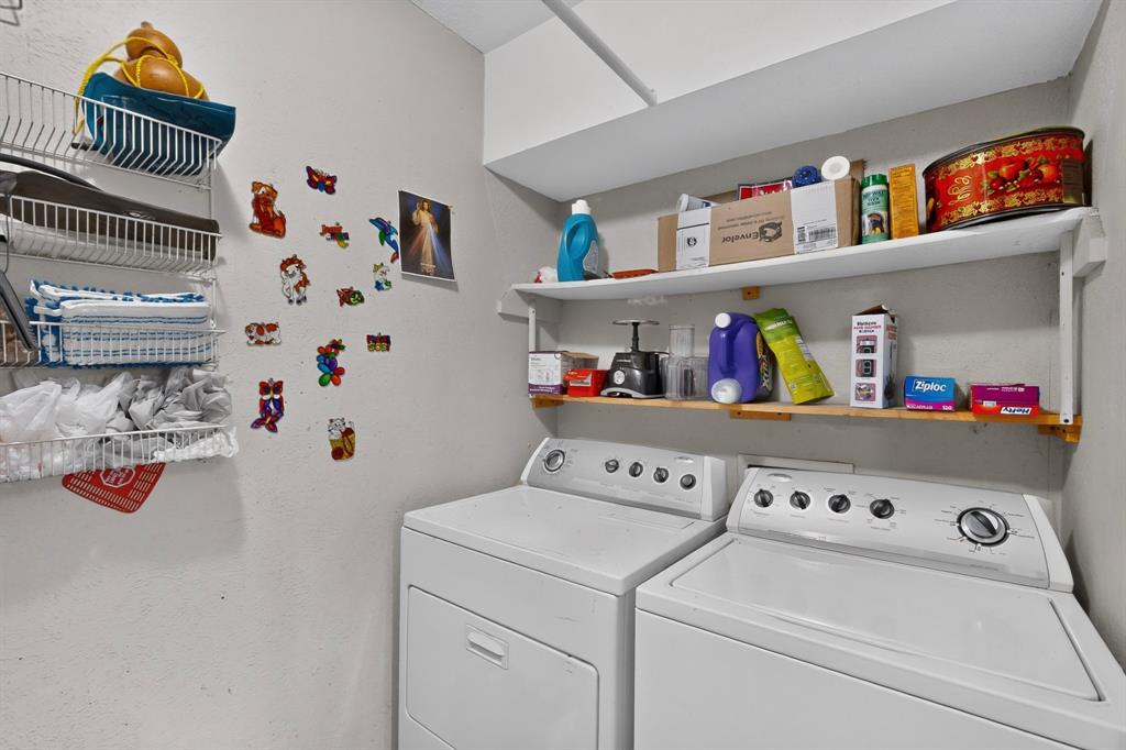 Utility space featuring wall-mounted wire shelving, open fixed-mount wooden shelving, and overhead storage cabinetry