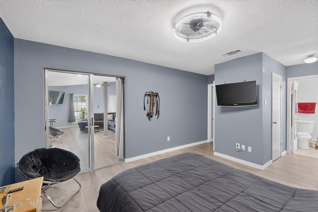 Neutral wall tones, wood-finish flooring, recessed lighting, and a modern circular ceiling fan with integrated illumination