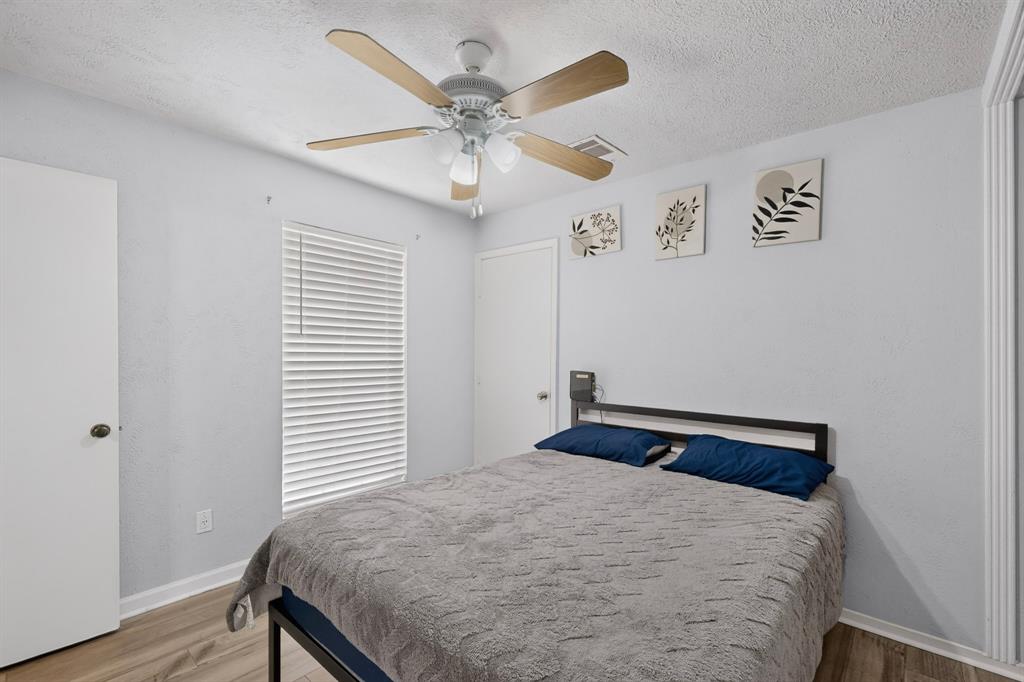 Wood-finish flooring, ceiling fan with integrated lighting, and horizontal window blinds