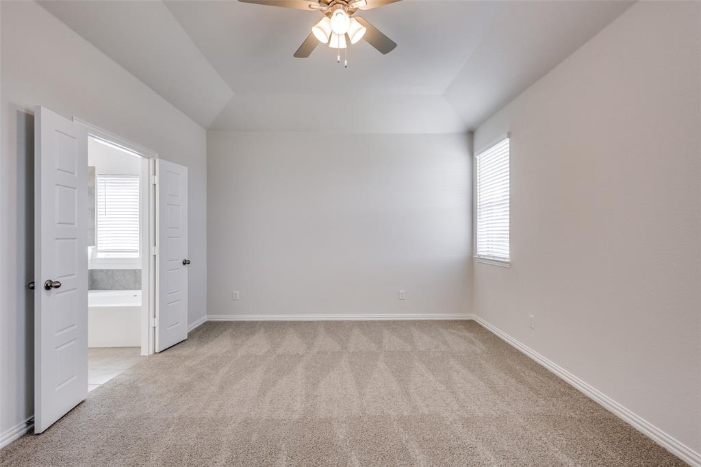 Empty room with light colored carpet, baseboards, and a ceiling fan