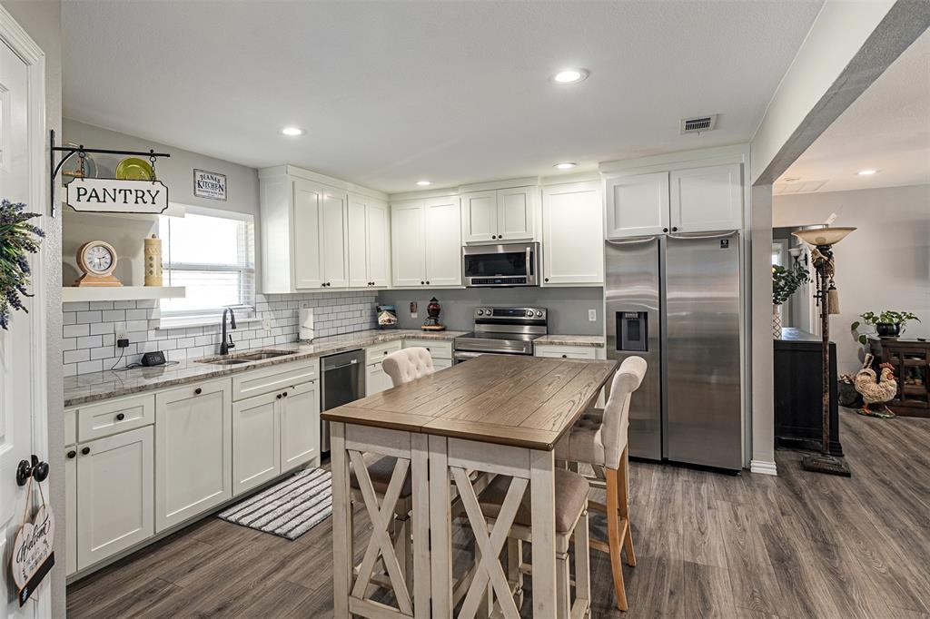 Kitchen featuring white cabinetry, stone-finish countertops, subway tile backsplash, recessed lighting, and wood-finish flooring