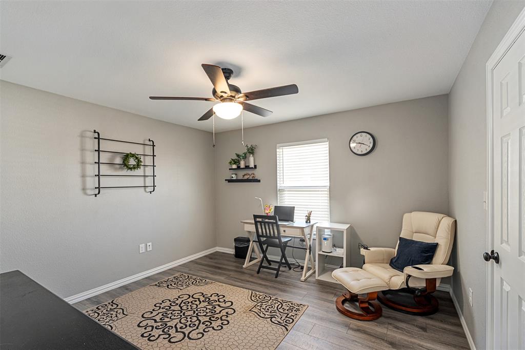 Neutral wall color, wood-finish flooring, and ceiling fan with integrated lighting