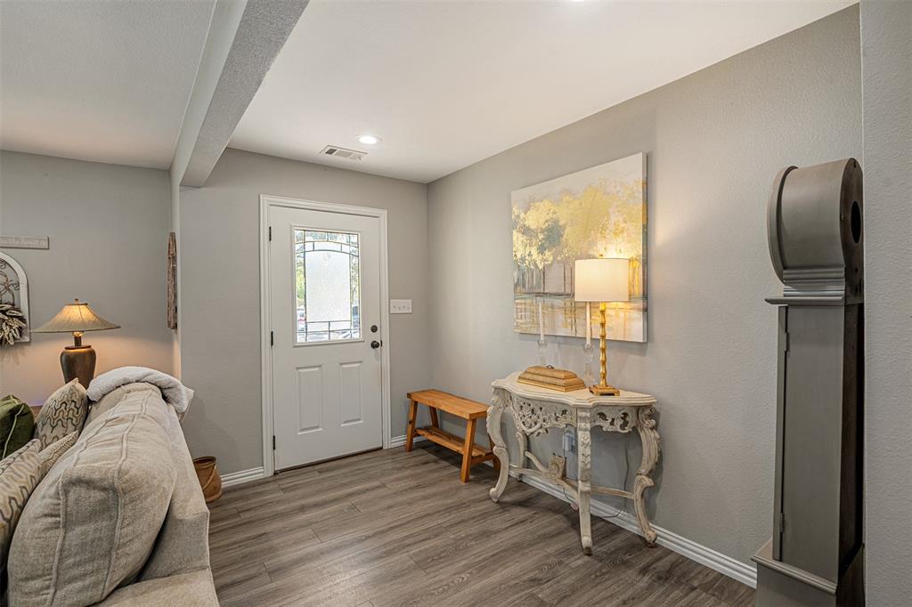 Entryway featuring wood-finish flooring, neutral wall paint, and an exterior door with decorative glass paneling Entryway featuring wood-finish flooring, neutral wall paint, and an exterior door with decorative glass paneling