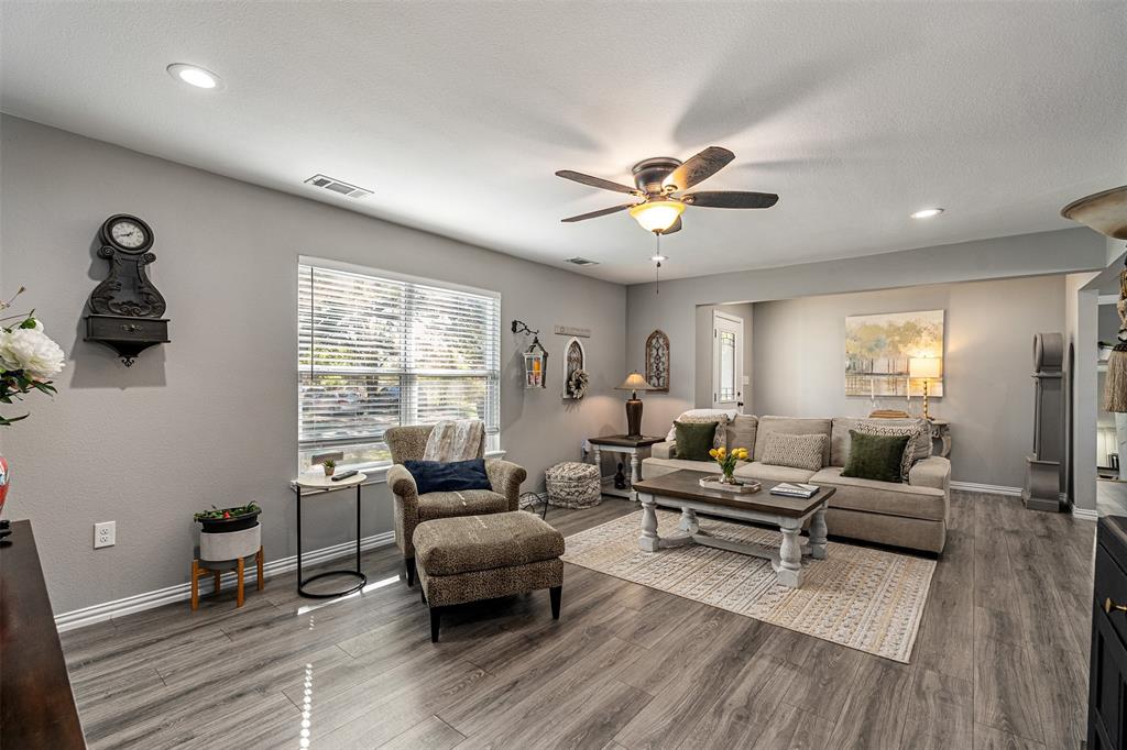 Wood-finish flooring, recessed lighting, and a ceiling fan with integrated light fixture Wood-finish flooring, recessed lighting, and a ceiling fan with integrated light fixture