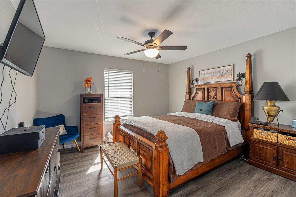 Wood-finish flooring, ceiling fan with integrated lighting, and horizontal window blinds