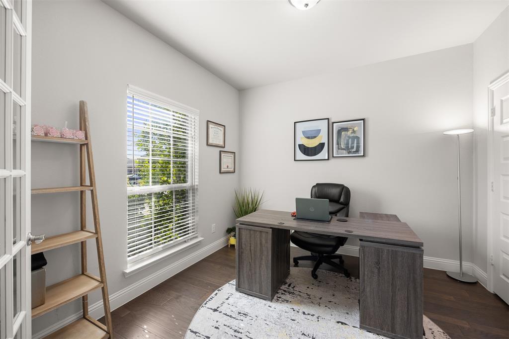 Multi-purpose room featuring wood-finish flooring, a glass-panel French door, and a single-hung window with blinds