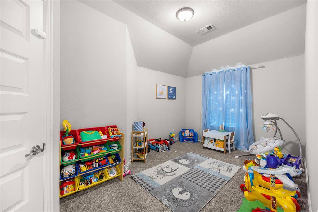 Room featuring vaulted ceilings, neutral wall tones, carpeted flooring, and a flush-mount ceiling light fixture