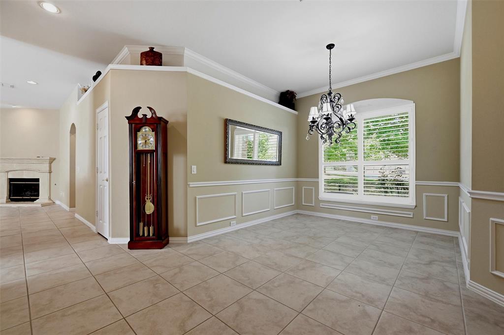 Dining area featuring tile flooring, decorative wall molding, a multi-arm chandelier, and plantation shutters
