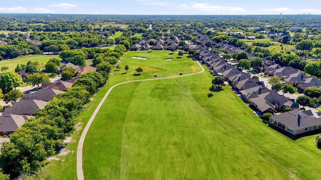 Aerial perspective featuring expansive greenbelt space, paved pedestrian pathway, mature tree canopy, and residential landscape