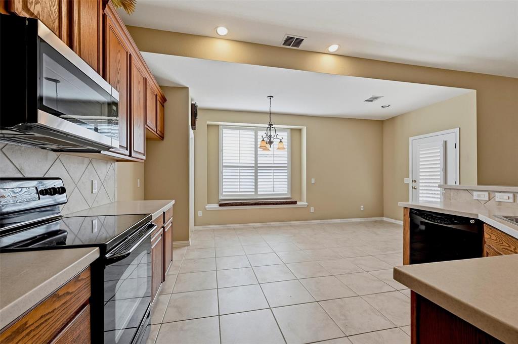 Kitchen featuring wood cabinetry, solid surface countertops, tile flooring, built-in window seat, and diamond-pattern tile backsplash