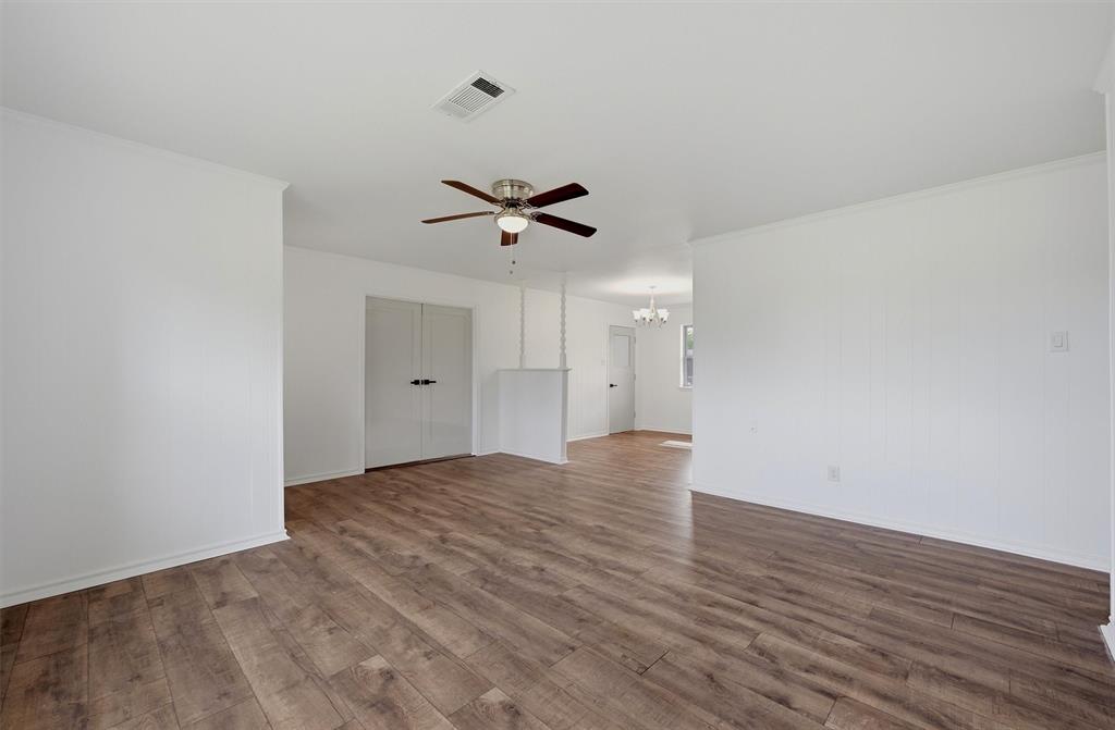 Interior space featuring wood-finish flooring, a ceiling fan with integrated lighting, and dual-panel closet doors Interior space featuring wood-finish flooring, a ceiling fan with integrated lighting, and dual-panel closet doors
