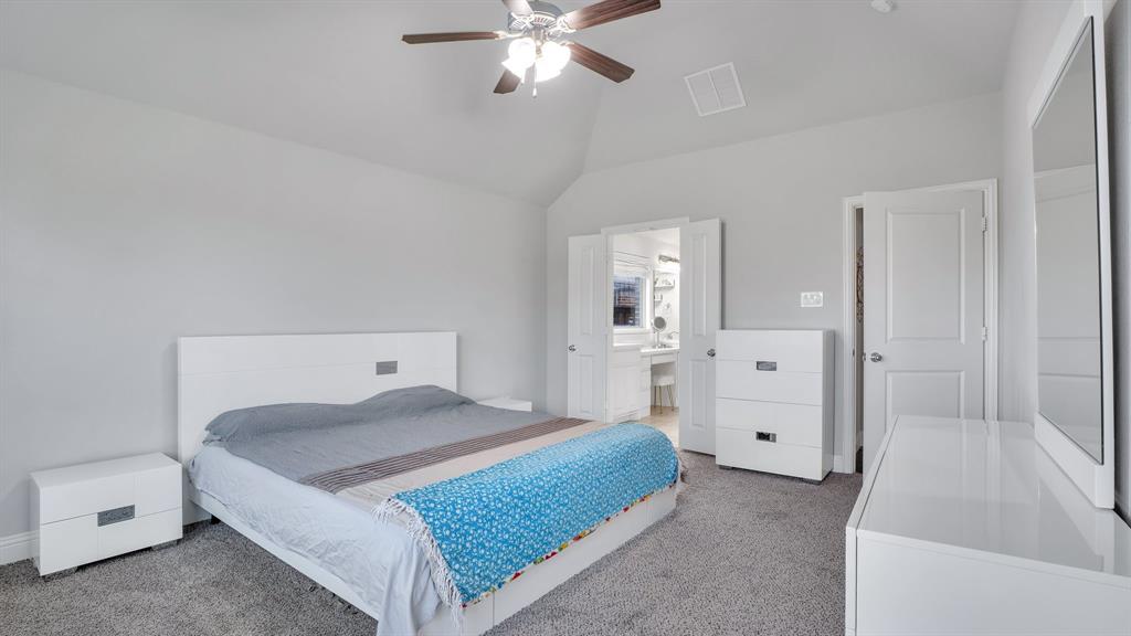 Vaulted ceilings, neutral wall color, carpeted flooring, and a multi-blade ceiling fan with integrated light fixture Vaulted ceilings, neutral wall color, carpeted flooring, and a multi-blade ceiling fan with integrated light fixture