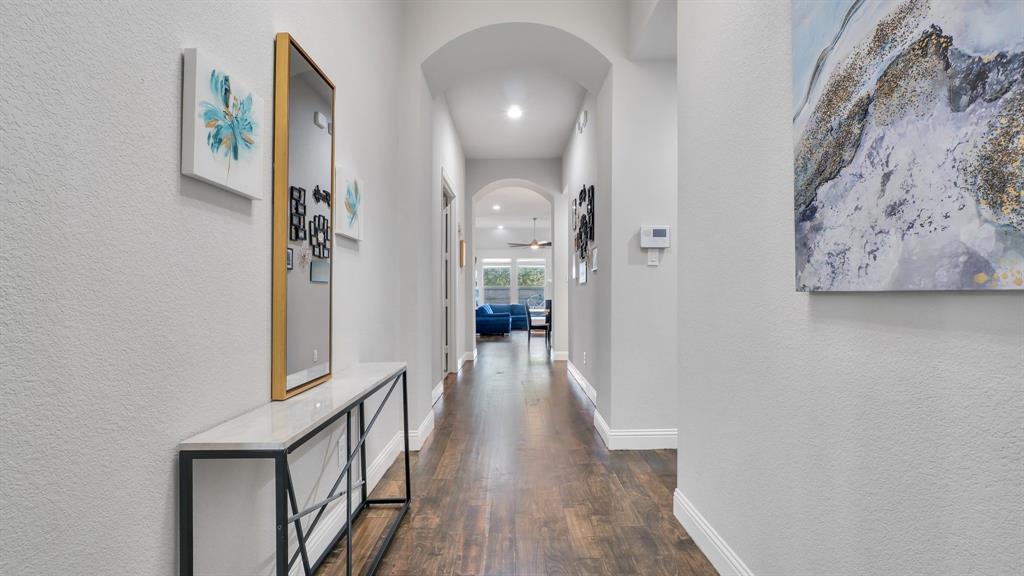 Hallway featuring arched architectural details, wood-finish flooring, and recessed lighting Hallway featuring arched architectural details, wood-finish flooring, and recessed lighting