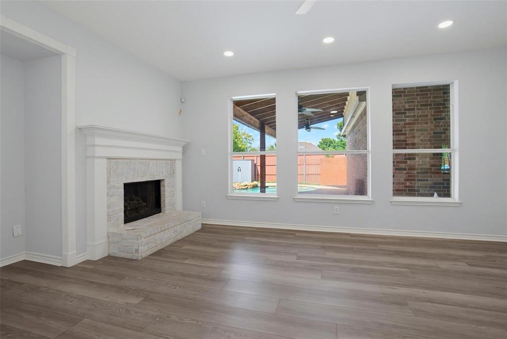 Interior featuring wood-finish flooring, recessed lighting, and a white brick fireplace with a custom mantle