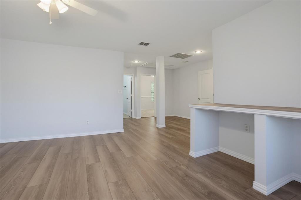 Open floor plan featuring wood-finish flooring, recessed lighting, a ceiling fan, and a built-in counter surface Open floor plan featuring wood-finish flooring, recessed lighting, a ceiling fan, and a built-in counter surface