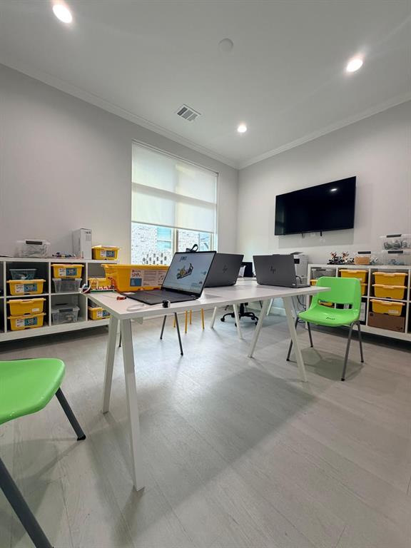 Room featuring light-toned wood-finish flooring, recessed lighting, and wall-mounted television bracket