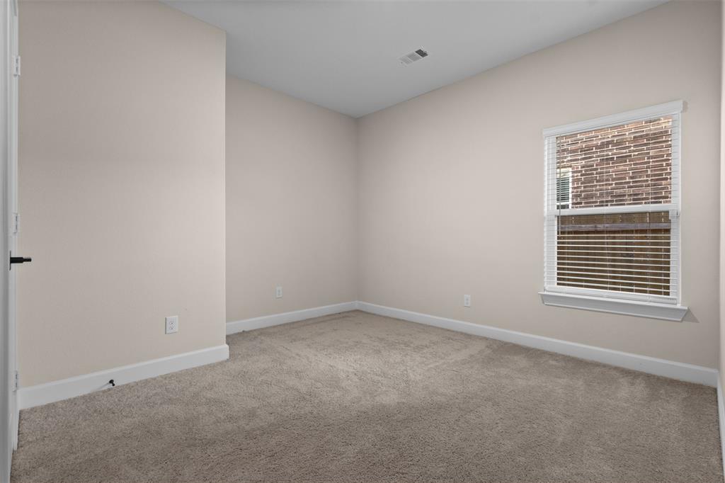 Neutral interior space featuring neutral wall paint, carpeted flooring, a single window with white horizontal blinds, and a solid interior door