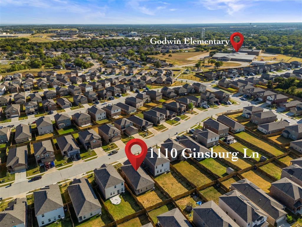 Aerial perspective showcasing a residential property situated within a suburban grid, featuring a fenced rear yard and proximity to educational facilities