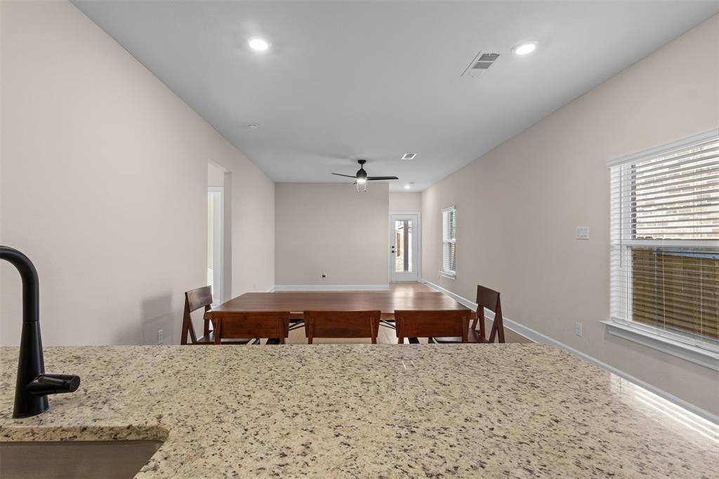 Speckled stone countertop with a matte black faucet, recessed lighting, and ceiling fan fixture